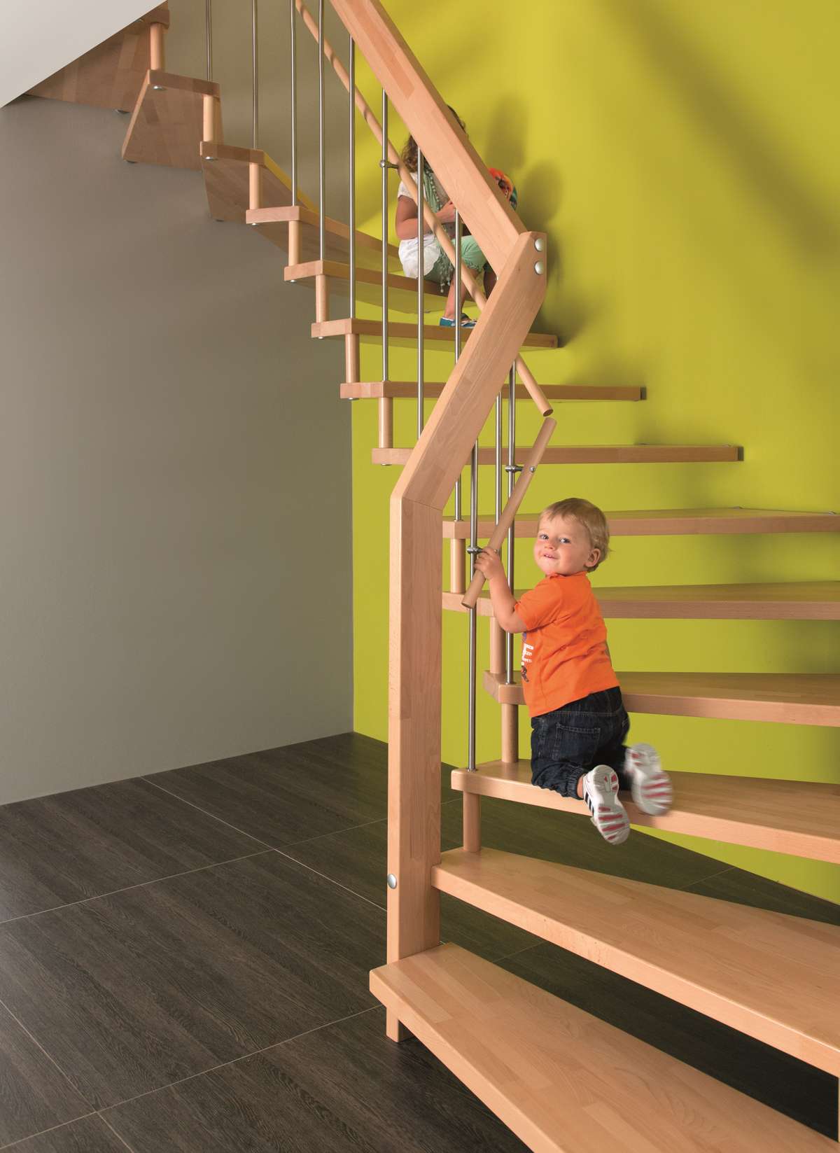 Kind auf einer Treppe mit Kinderhandlauf